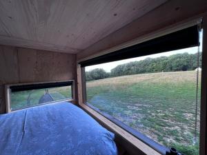 海斯廷斯Hop and hare farm的一间卧室,透过窗户可欣赏到田野景色