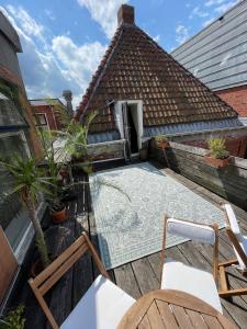 格罗宁根Julius Groningen的一个带椅子和瓷砖屋顶的户外庭院