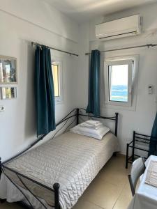 ParánimfoiHouse With View的一间卧室配有一张带绿色窗帘的床和窗户。