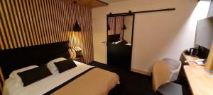 拉罗谢尔丽布立思酒店的酒店客房配有一张床、一张桌子和一把椅子。