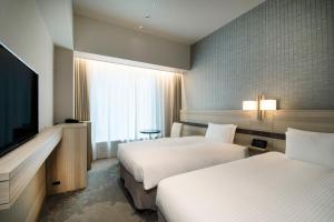 东京京阪築地银座格兰德酒店的酒店客房设有两张床和一台平面电视。