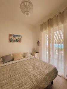 贝尔韦代雷Appartamento Corallo Rosso e Stella Blu的一间卧室设有一张床和一个大窗户