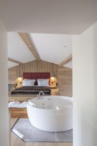 伊苏瓦尔Hôtel & Restaurant Origines par Adrien Descouls - Teritoria的卧室配有浴缸,卧室配有床