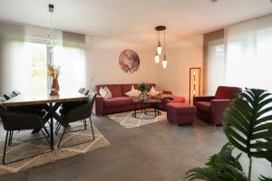 维林根Appartementhaus kleines Glück &MeineCardPLUS的客厅配有红色的沙发和桌子