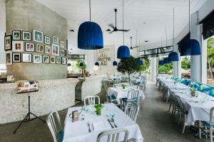 芭堤雅市中心Hard Rock Hotel Pattaya的用餐室配有白色的桌子和蓝色的灯光