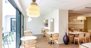 比亚里茨贝斯特韦斯特科马里酒店的一间带桌椅和花瓶的餐厅