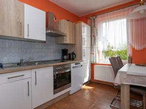 乌曼茨Apartment Am Strom-3 by Interhome的厨房配有白色橱柜、水槽和炉灶。