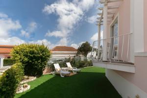 阿托吉亚达巴莱亚Villa Juno的一个带两把椅子的庭院和一个阳台