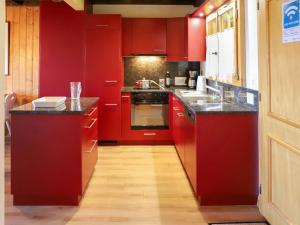 威拉尔-苏-罗伦Apartment Argentière 8 by Interhome的厨房配有红色橱柜和黑色台面