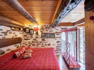 BognancoChalet Il Gianlupo by Interhome的一间位于石墙房间内的卧室,配有一张红色的床