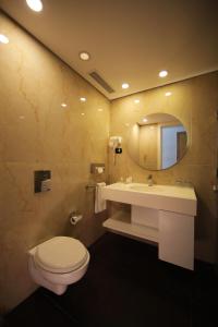 贝鲁特Riviera Hotel and Beach Lounge, Beirut的一间带卫生间、水槽和镜子的浴室