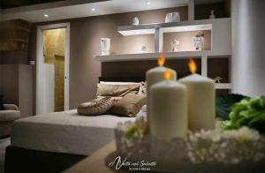 托尔基亚罗洛AvVolta nel Salento - Room & Relax的一间卧室配有一张带两张蜡烛的床。