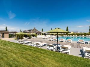 贝梅伦Holiday Home Green Resort Mooi Bemelen by Interhome的一个带白色躺椅和遮阳伞的游泳池