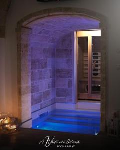 托尔基亚罗洛AvVolta nel Salento - Room & Relax的客房内的蓝色灯光热水浴池