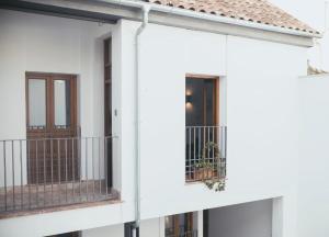 科尔多瓦Trigo Homes的白色的房子,设有两个阳台和门