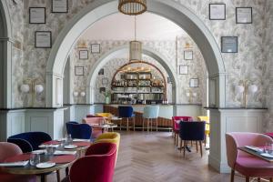 罗马UNAHOTELS Trastevere Roma的一间带桌椅的餐厅和一间酒吧