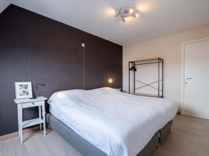 布列登Apartment Residentie Zandloper II by Interhome的卧室配有一张白色大床和黑色墙壁