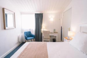 诺亚芒提亚芙蓉塞尔酒店的一间卧室配有一张床、一张蓝色椅子和一张书桌