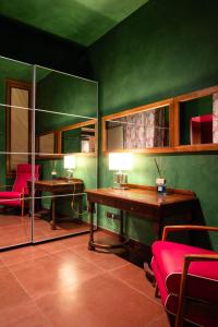 佛罗伦萨卡拉瓦乔酒店的绿色的客房配有书桌和桌椅