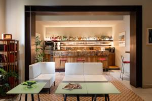 佛罗伦萨卡拉瓦乔酒店的一间带两把白色椅子的客厅和一间酒吧