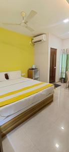 JalpāiguriCHIRAGDEEP BANQUET HALL AND LODGING的一间卧室设有一张黄色墙壁的大床