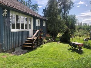 MunkforsRustic Haven Bed and Breakfast near Klarälvsbanan and Swimming area的一座小房子,设有木楼梯,毗邻院子