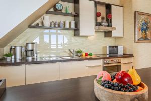 朗克维茨Wellness-Apartment mit Wasserblick, Pool, Sauna & Fitnessbereich的厨房里放着一碗水果放在桌子上