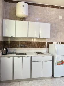 沙鲁拉الراحة بلازا للشقق المفروشة的厨房配有白色橱柜和白色冰箱。
