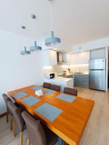 卡塔海滩Q Conzept apt 2br new的厨房以及带木桌和椅子的用餐室。