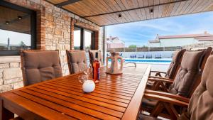 坎法奈尔Villa Baraka的一间带木桌和游泳池的用餐室