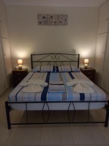 AnálipsisAngela's Cute Apartment (A/C, WiFi, Little Garden)的一张带蓝色和白色床单的床和两盏灯