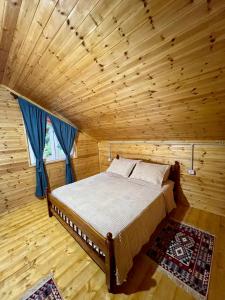 斯库台Guesthouse Zgiboza的木制客房内的一间卧室,配有一张床