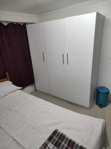 南迪Town Centre Stays的卧室配有2个白色橱柜和1张床