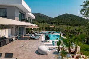 斯卡拉拉乔伊Nooa Villas的一座别墅,设有游泳池和山脉