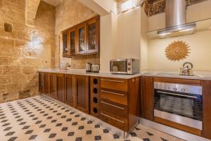 瓦莱塔Stunning Valletta Palazzino的厨房配有木制橱柜和炉灶。