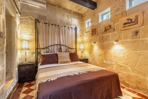 瓦莱塔Stunning Valletta Palazzino的一间卧室设有一张床和石墙