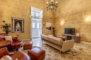 瓦莱塔Stunning Valletta Palazzino的客厅配有皮革家具和电视