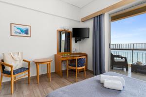 阿马林索斯Stefania Hotel的酒店客房设有一张床、一张书桌和一个阳台。