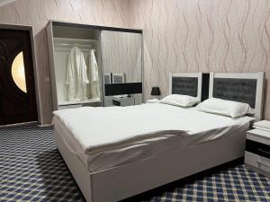 费尔干纳Orom Hotel Fergana的一间卧室设有一张大床和一个大镜子