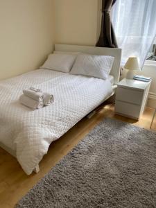 伦敦City gem的一间卧室配有一张带白色床单和地毯的床。