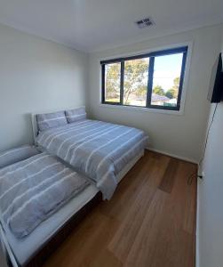 墨尔本Maruve Guesthouse 12 min from Melb airport的一间卧室设有一张床和一个窗口