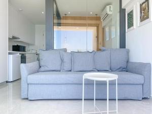 帕福斯Phaedrus Living: Marina Sea View Flat 214 Emerald的客厅配有一张蓝色的沙发,配有一张桌子