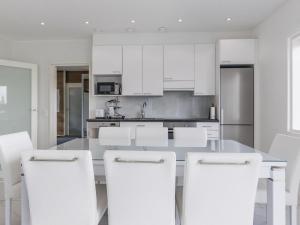 SalmentakaHoliday Home Villa hirvas by Interhome的厨房配有白色橱柜和白色凳子