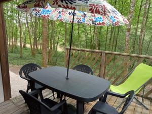 Bretagne-dʼArmagnacMobile Home的甲板上的桌子和遮阳伞