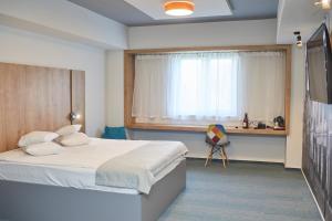 比斯特里察比斯特里察酒店的一间卧室配有一张床、一个窗口和一张书桌