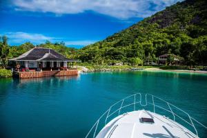 锡卢埃特岛塞舌尔拉布里兹希尔顿度假及Spa酒店的湖边房子旁边的水中的小船