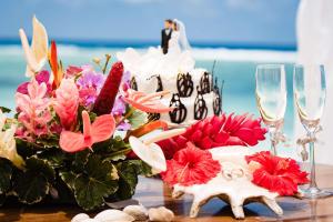 锡卢埃特岛塞舌尔拉布里兹希尔顿度假及Spa酒店的一张桌子,上面放着婚饼、鲜花和酒杯