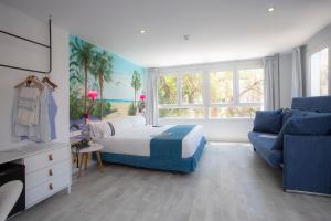 马拉加Casual del Mar Málaga的一间卧室配有一张床和一张蓝色的沙发