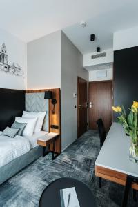 克拉科夫Garden Square Hotel的酒店客房配有一张床铺和一张桌子。