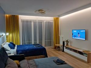 比亚韦斯托克Apartament Centrum Białystok的客厅配有蓝色的床和电视